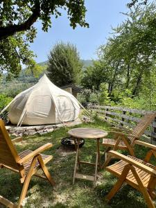 Andrijevica的住宿－Glamping Zvjezdana dolina，一组椅子、一张桌子和一个帐篷