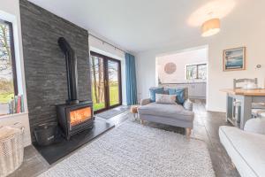 a living room with a fireplace and a couch at Cow Barn, Duddon Bridge in Broughton in Furness