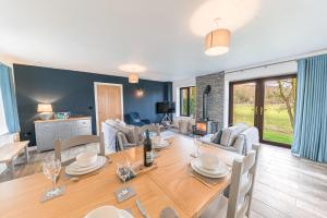 uma sala de jantar e sala de estar com mesa e cadeiras em Cow Barn, Duddon Bridge em Broughton in Furness