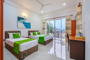 two beds in a room with a balcony at Queens mount Ridge in Kandy