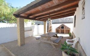 eine Terrasse mit einem Holztisch und einer Bank in der Unterkunft Casa Samuel Mayorazgo con piscina compartida in Cádiz