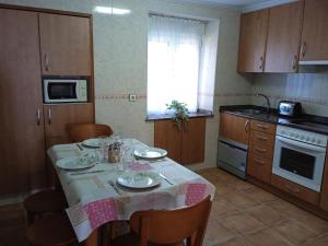 a kitchen with a table with a table cloth on it at La Corralada de Merón in San Vicente de la Barquera