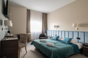 Pokój hotelowy z łóżkiem i krzesłem w obiekcie Złoty Staw w Gdańsku