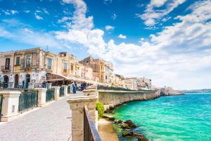 een uitzicht op een kanaal met gebouwen en het water bij SyracuseApartments il mare di Ortigia in Siracusa