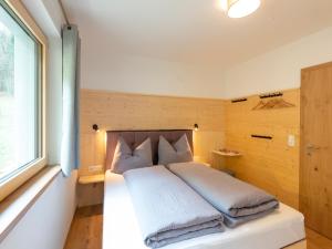 a bedroom with a bed with pillows and a window at Haus Heimat - Alpenrose 