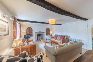 a living room with two couches and a fireplace at Thwaite Cottage Coniston in Coniston