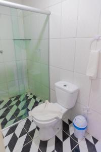 a bathroom with a toilet and a glass shower at Pousada Summer Beach by AFT in Porto De Galinhas