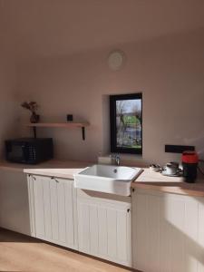 una cucina con lavandino e piano di lavoro di Komo Hill Stays - guestroom Komo Cosy a Kruisem