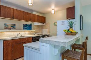 a kitchen with a counter with a bowl of fruit on it at Waikomo Streams 121 in Koloa