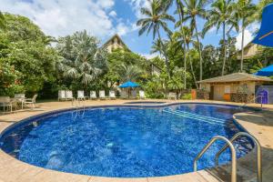 a swimming pool in a resort with palm trees at Waikomo Streams 121 in Koloa