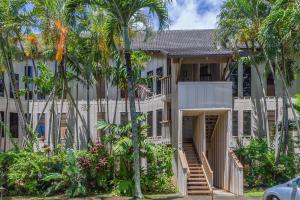 a building with palm trees in front of it at Waikomo Streams 121 in Koloa