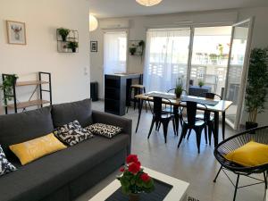 a living room with a couch and a dining room at Appart T3 Standing - Terrasse - 2 Parkings in Montpellier