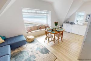 uma sala de estar com uma mesa e um sofá azul em WOOLACOMBE SUNNYSIDE APARTMENT 2 Bedrooms em Woolacombe