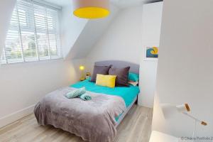 um quarto com uma cama num quarto branco em WOOLACOMBE SUNNYSIDE APARTMENT 2 Bedrooms em Woolacombe
