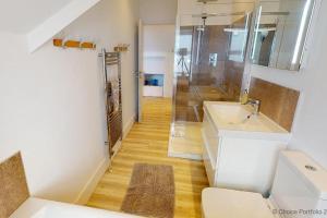 uma casa de banho com um WC, um lavatório e um chuveiro em WOOLACOMBE SUNNYSIDE APARTMENT 2 Bedrooms em Woolacombe