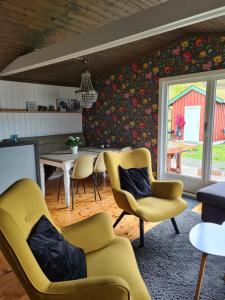 Nordfjordcabins Utvik في Utvik: غرفة معيشة مع كراسي صفراء وطاولة