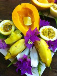 a plate of fruits and vegetables on a table at Coconut Grove Beachfront Cottages in Matei