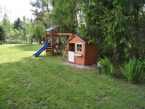 a playground with a house and a slide at Mikolajek Nadmorski in Dębki