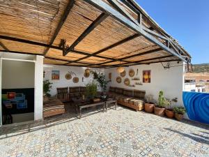 un patio con tetto in legno, tavolo e panche di Happy Surf Hostel a Taghazout