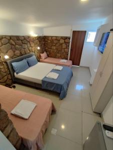 a bedroom with two beds and a stone wall at Guest House "Villa Klara Eilat" Heated pool and sauna all year round in Eilat