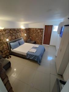 a bedroom with a bed and a stone wall at Guest House "Villa Klara Eilat" Heated pool and sauna all year round in Eilat