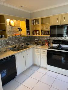 uma cozinha com armários brancos e electrodomésticos pretos em Creek View Townhome em Augusta