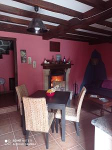 comedor con mesa, sillas y chimenea en Casa Capricho, en Proaza