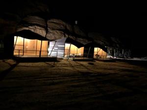 a group of tents in a field at night at Wadi Rum Moon Camp in Wadi Rum