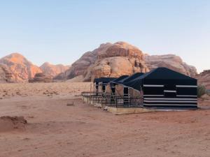 a group of tents in the desert with rocks at Wadi Rum Moon Camp in Wadi Rum