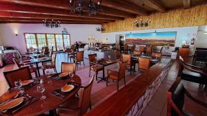 un restaurante con mesas y sillas y una pantalla grande en Hotel Diego de Almagro San Pedro De Atacama, en San Pedro de Atacama