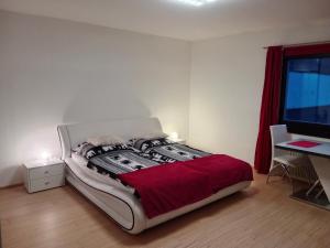 um quarto com uma cama grande e um cobertor vermelho em Dachstein Apartments em Obertraun