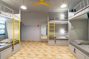Cette chambre dispose de 3 lits superposés et d'un plafond. dans l'établissement Whoopers Hostel Anjuna, Goa, à Anjuna