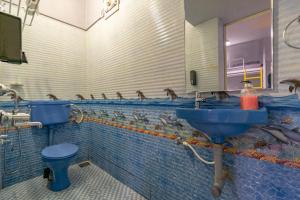 a bathroom with a sink and birds on the wall at Whoopers Hostel Anjuna, Goa in Anjuna