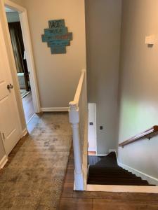 a hallway with a staircase with a sign on the wall at Creek View Townhome in Augusta