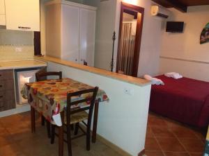 a kitchen with a table and a bed in a room at APPARTAMENTO A SAN VITO LO CAPO STANZA CON BAGNO in San Vito lo Capo