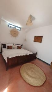 Dar Malwan في مراكش: غرفة نوم مع سرير كبير مع سجادة كبيرة على الأرض