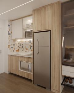 a kitchen with a refrigerator and wooden cabinets at Moov 1417 Studio Mooca in São Paulo