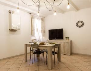 a dining room with a table and chairs and a tv at Suite Garibaldi - Smart Holiday in Mantova