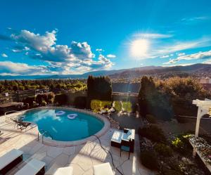 a pool on a patio with a view of the mountains at A Vista Villa Couples Retreat in Kelowna