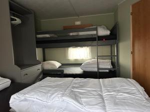 1 dormitorio con 2 literas y 1 cama en Retro Stacaravan, en Warmond