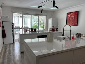 kuchnia z białym blatem i lodówką w obiekcie Une pause…au soleil Classé 4 étoiles 108 m2 à 3min à pieds de la plage w mieście La Grande-Motte