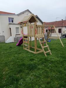 a wooden play set in a yard at Jolie maison à 200 m des plages du débarquement in Saint-Aubin-sur-Mer