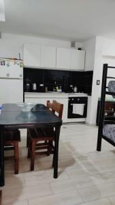 una cucina con tavolo e sedie e una cucina con piano cottura di Departamento para 4 personas en ezeiza a Ezeiza
