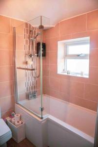 een badkamer met een douche, een toilet en een raam bij SL Luxury 3 Bedroom Home in Holly Lane