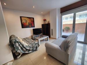 uma sala de estar com um sofá e uma cadeira em Badalona Beach Apartment em Badalona