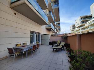 un patio con mesa y sillas en un edificio en Badalona Beach Apartment en Badalona