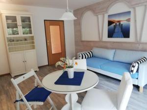 Stylish & Spacious Apartment with Patio في ستامس: غرفة معيشة مع أريكة زرقاء وطاولة وكراسي