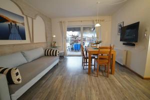 Stylish & Spacious Apartment with Patio في ستامس: غرفة معيشة مع أريكة وطاولة وكراسي