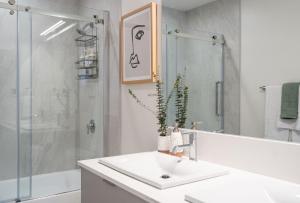 a white bathroom with a sink and a shower at Adanac by Revelstoke Vacations in Revelstoke