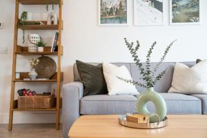 a living room with a couch and a vase on a table at Adanac by Revelstoke Vacations in Revelstoke